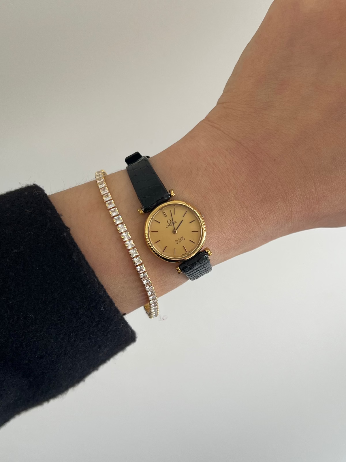 Close-up of the Omega De Ville champagne dial with gold markers and black accents.