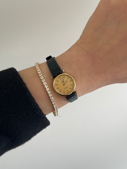 Close-up of the Omega De Ville champagne dial with gold markers and black accents.