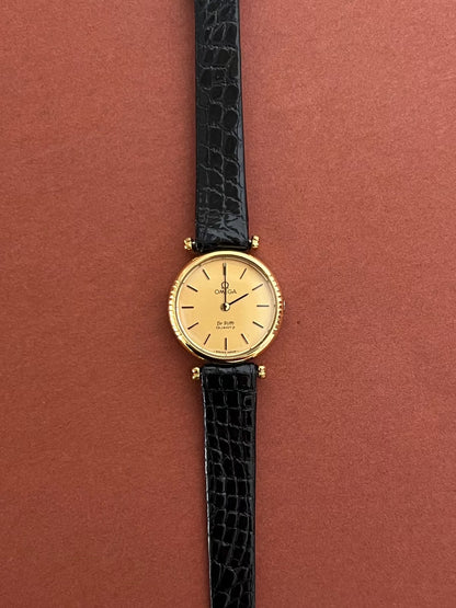 Detail of the black leather strap and gold-tone buckle on the Omega De Ville.