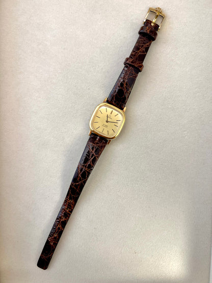 Close-up of the Omega De Ville dial with black baton markers and Omega emblem.