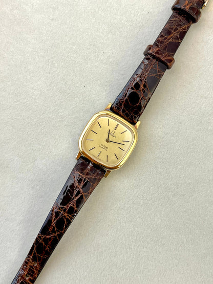 Angled view of the Omega De Ville soft-cushion case and gold-tone finish.
