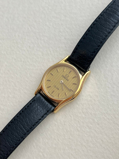 Vintage Omega watch with vertical textured gold dial.