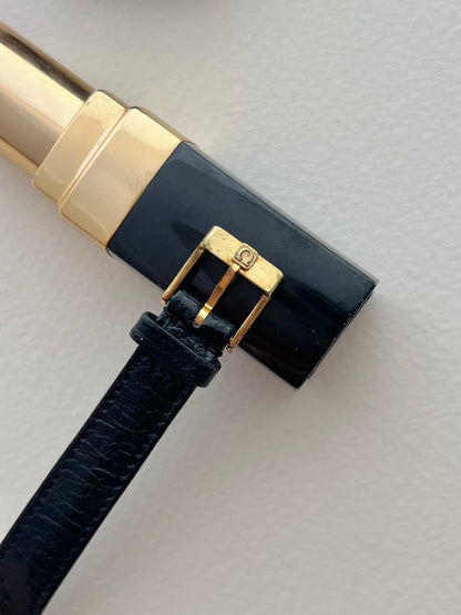 Omega De Ville textured dial watch with round gold-tone case.