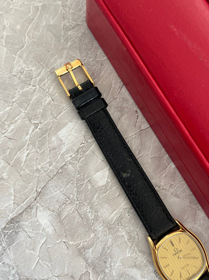 Gold-tone pin buckle and black leather strap detail on the Omega De Ville women's dress watch
