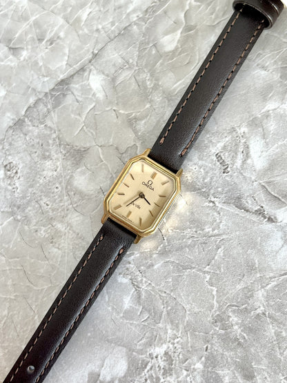 Angled view of Omega De Ville gold-tone clipped-corner rectangular case and champagne dial