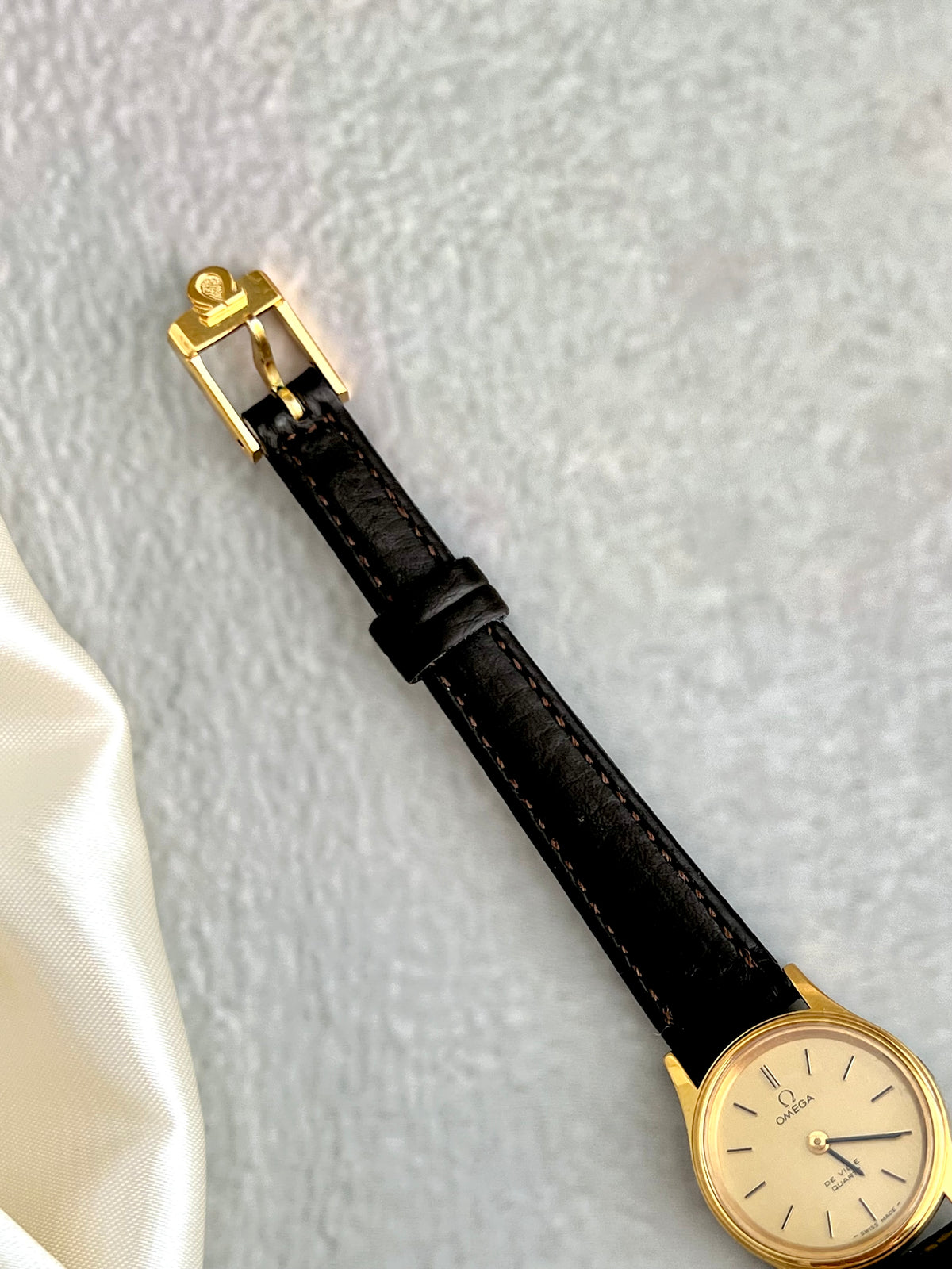 Brown leather strap detail on the Omega De Ville watch.