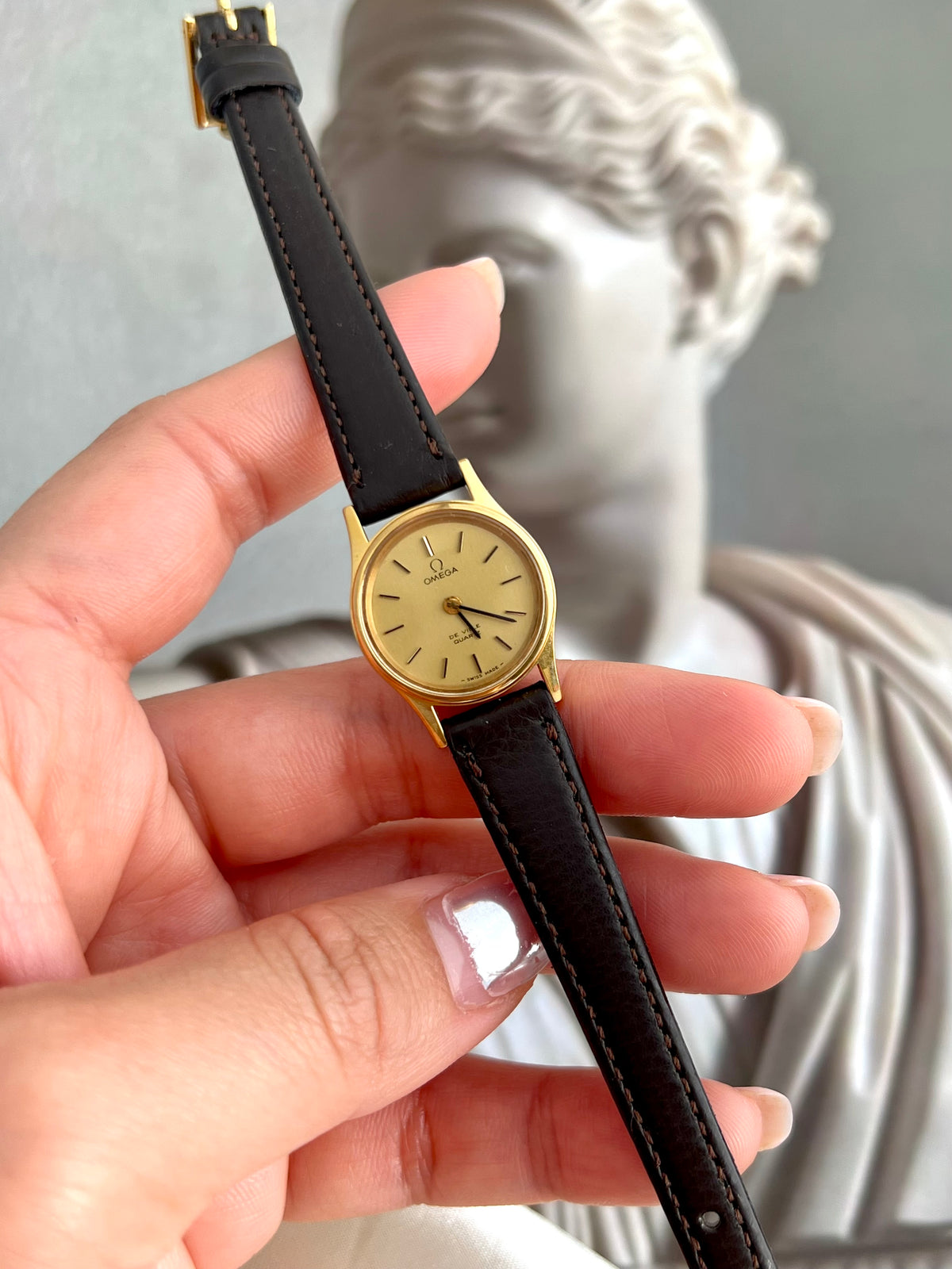 Front view of the Omega De Ville with champagne dial and black baton markers.