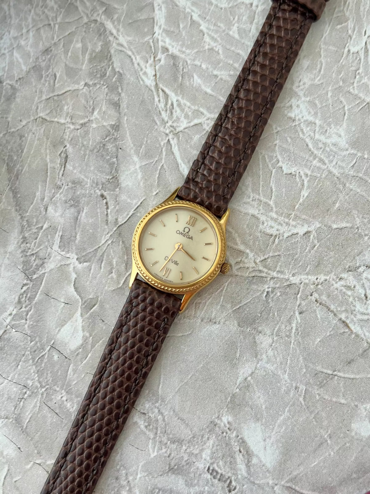 Omega De Ville Rope Bezel Brown Strap Watch: angled dial and brown textured strap.