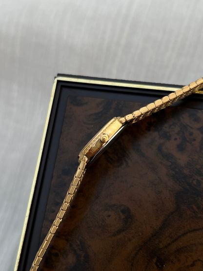 Omega De Ville gold-tone bracelet watch shown on a wrist.