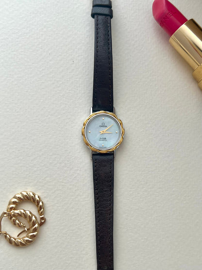 Close-up of the tightly woven gold-tone mesh bracelet on the Omega De Ville watch.