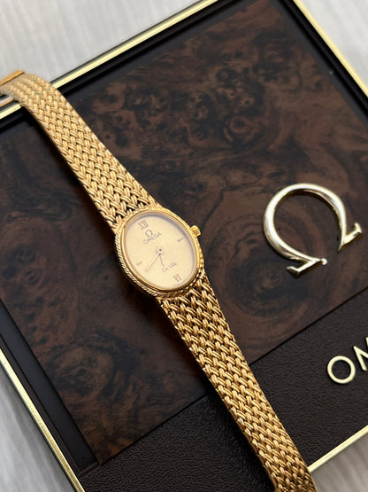 Front view of the vintage Omega De Ville gold-tone oval watch with champagne guilloché dial.