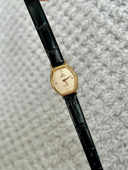 Omega De Ville gold tonneau ladies watch, front view.