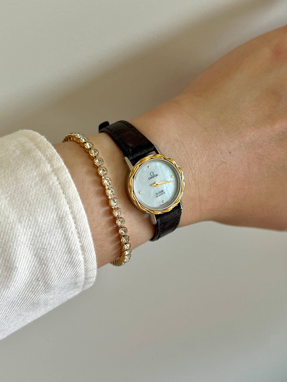 Close-up of the Omega De Ville mother-of-pearl dial and sculpted gold laurel bezel.