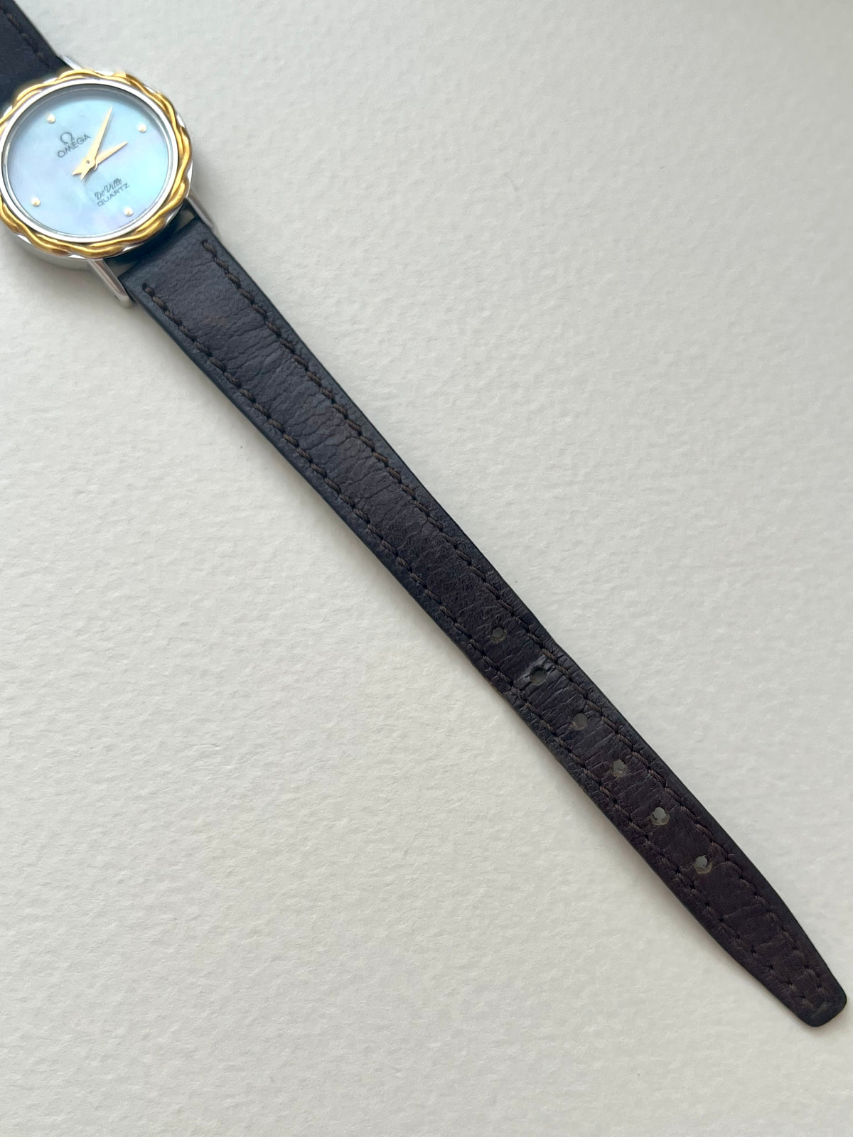 Detailed view of the Omega De Ville iridescent mother-of-pearl dial and gold dot hour markers.