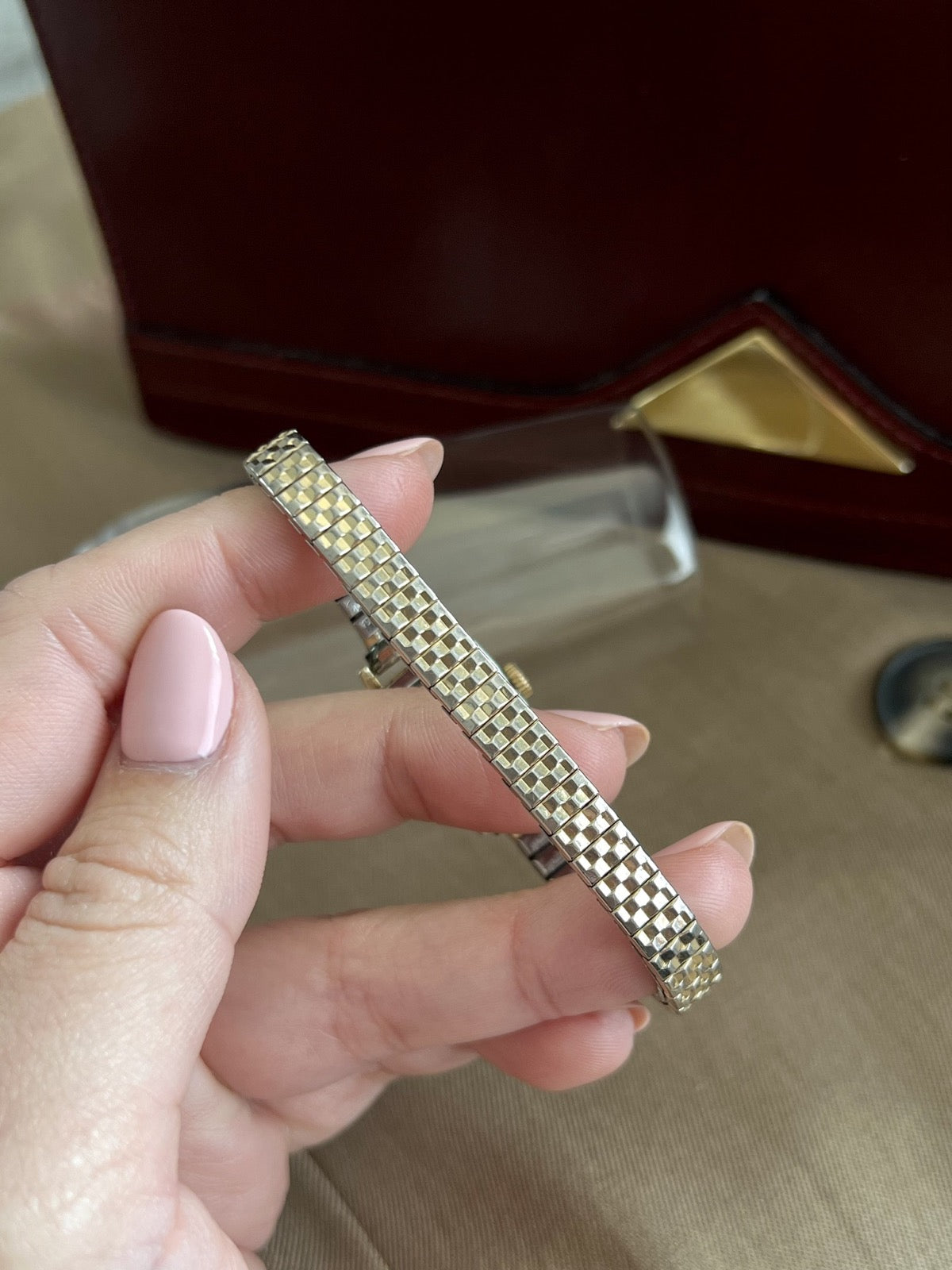 Detail of the geometric gold and silver tone links on the Omega De Ville women’s elastic bracelet