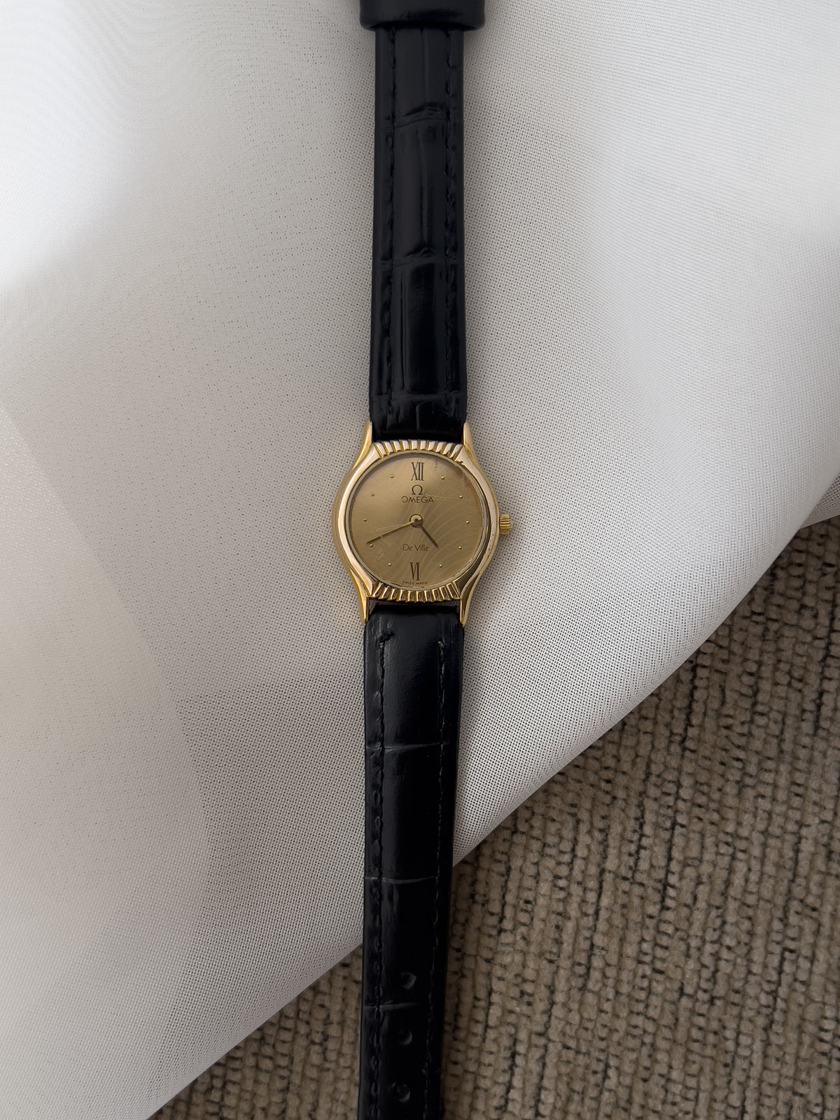 Omega De Ville gold-tone women's watch with patterned dial and black leather strap