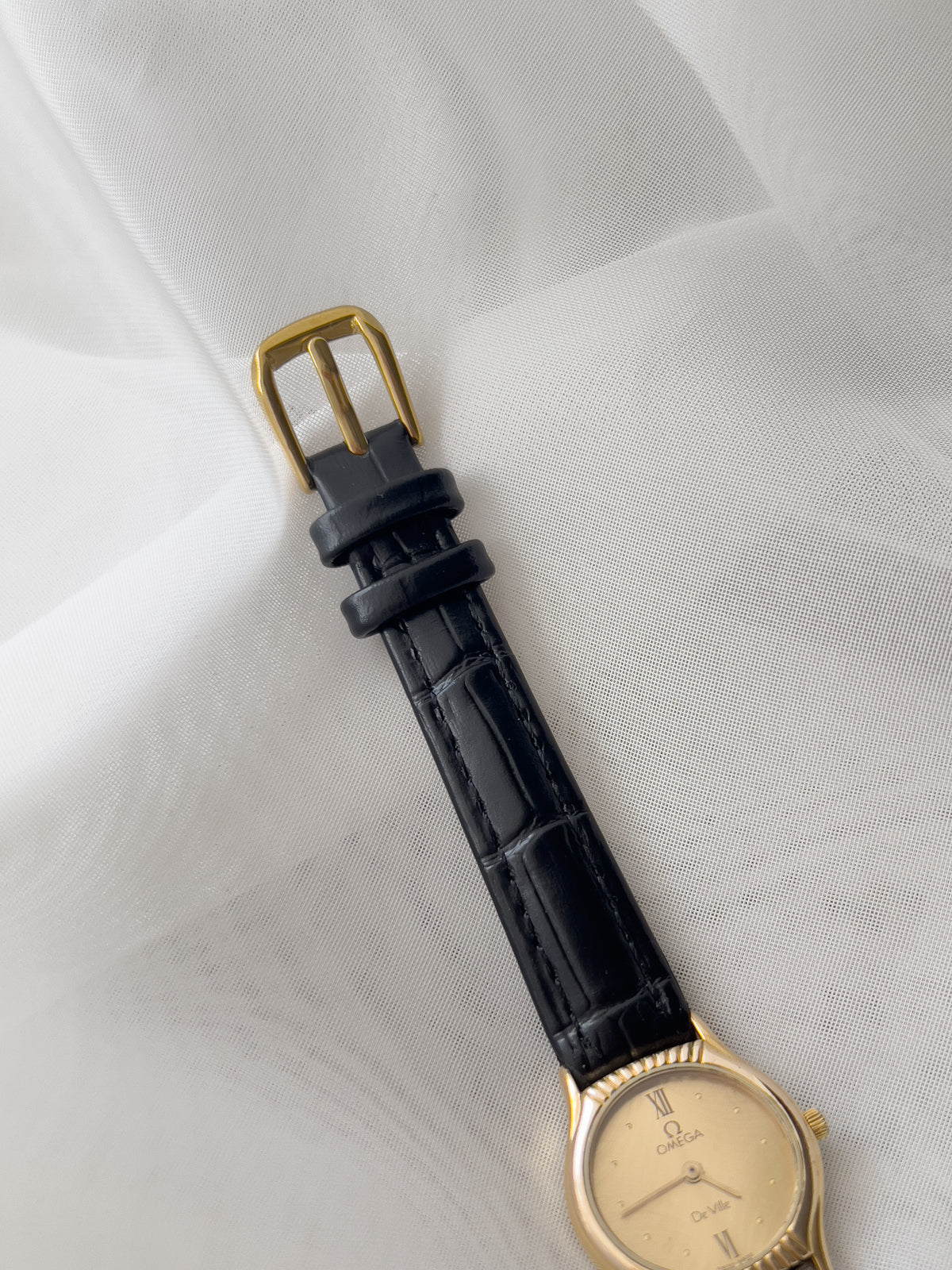 Omega De Ville gold-tone women's watch with patterned dial and black leather strap
