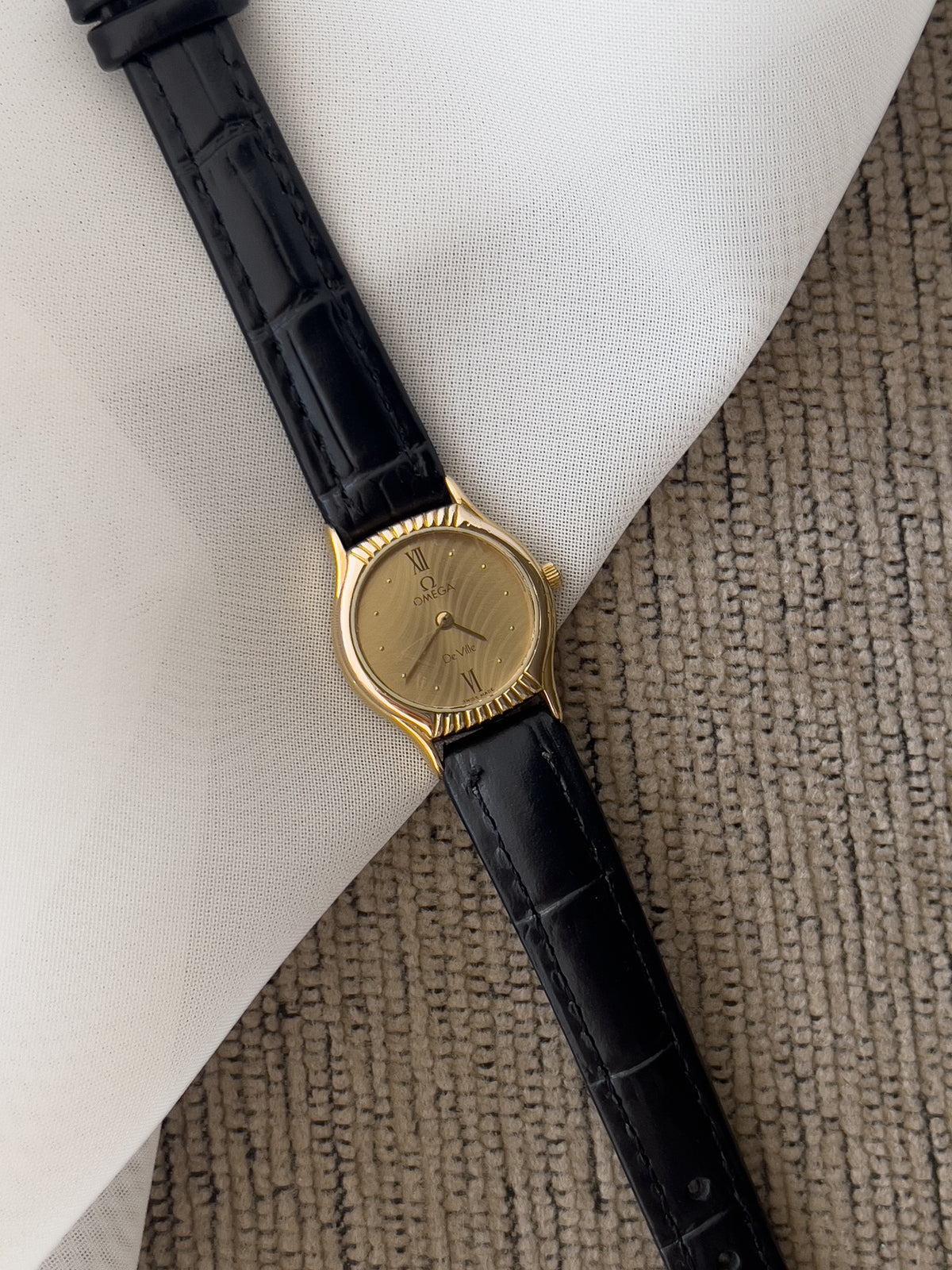 Omega De Ville gold-tone women's watch with patterned dial and black leather strap
