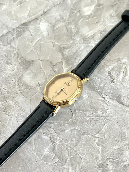 Angled view of Omega De Ville women's watch showing patterned gold-tone bezel and slim case — ref. 591.0257