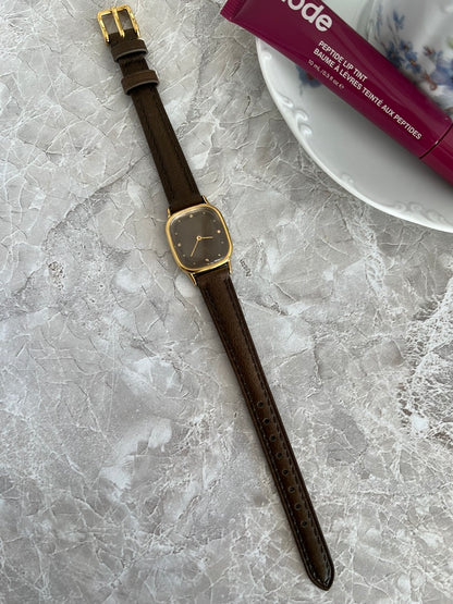 Full-length view of Omega De Ville gold-tone cushion watch on brown strap