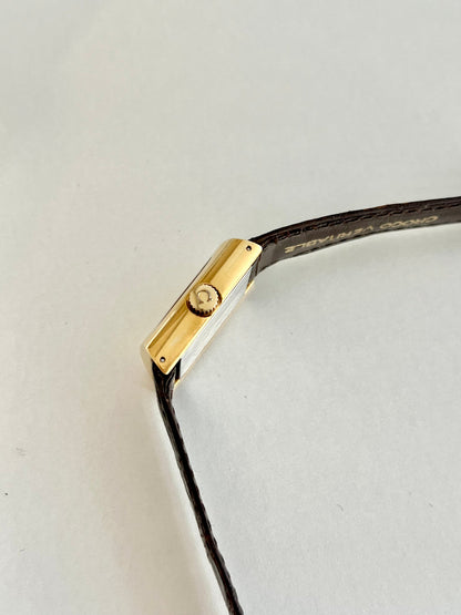Side profile of the gold-tone rectangular case on the Omega De Ville.