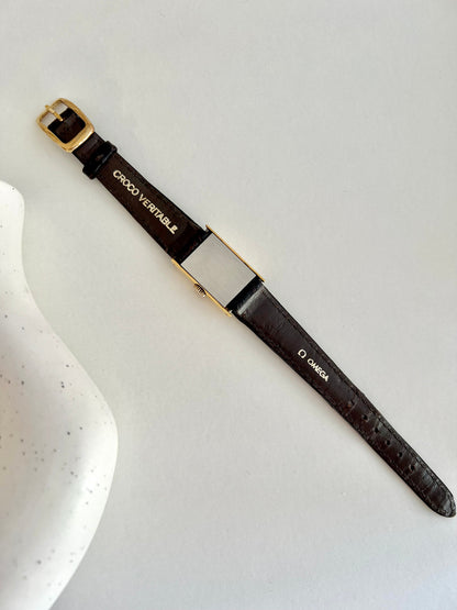 Detail of the original Omega croc-style strap and signed buckle.