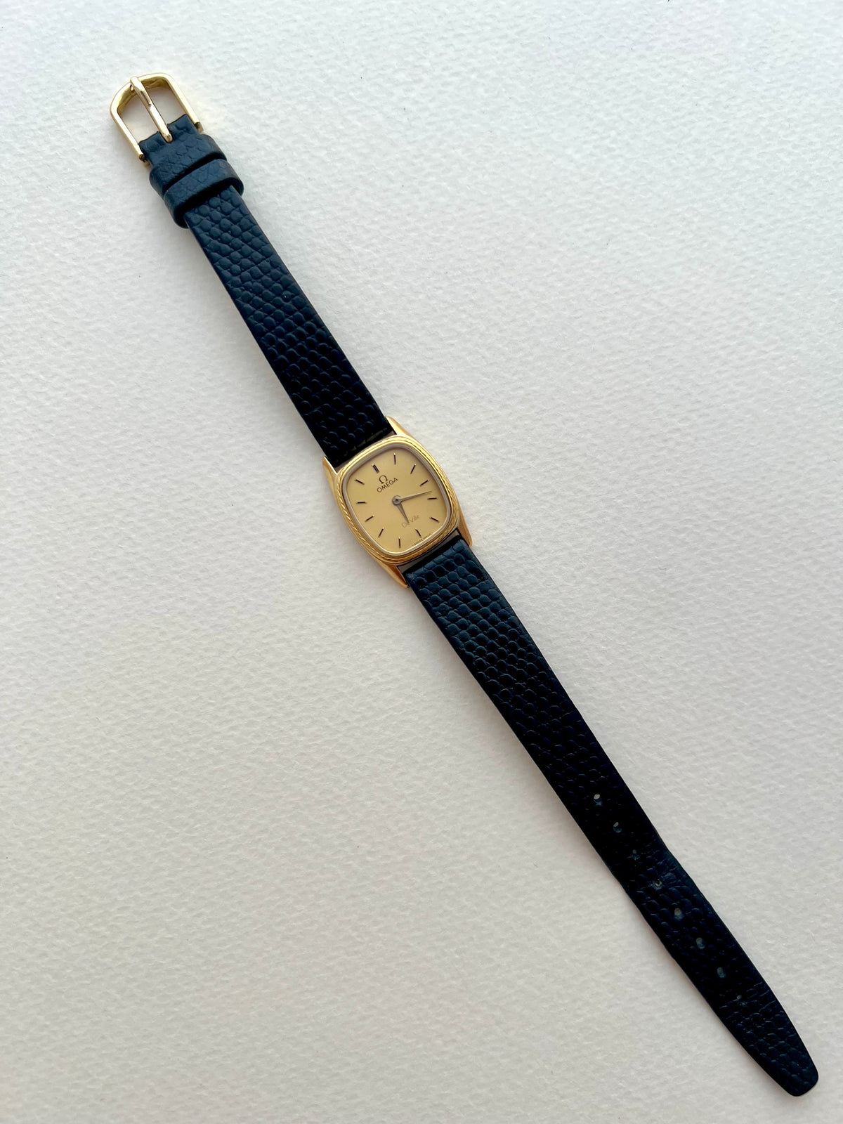Front view of the Omega De Ville ladies watch with a gold-tone cushion case and rope bezel.