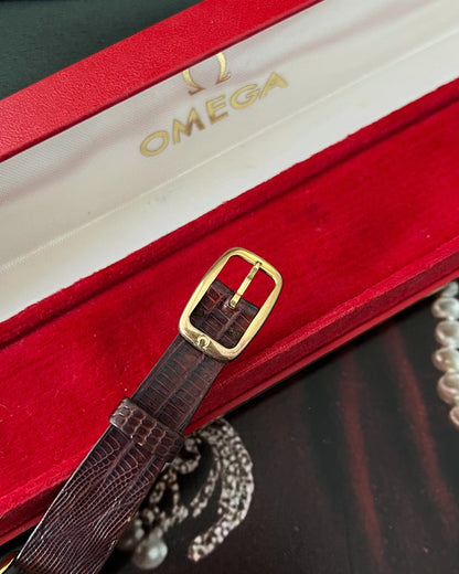 Close-up of the signed gold tone Omega buckle, brown lizard leather and Omega presentation box lining.