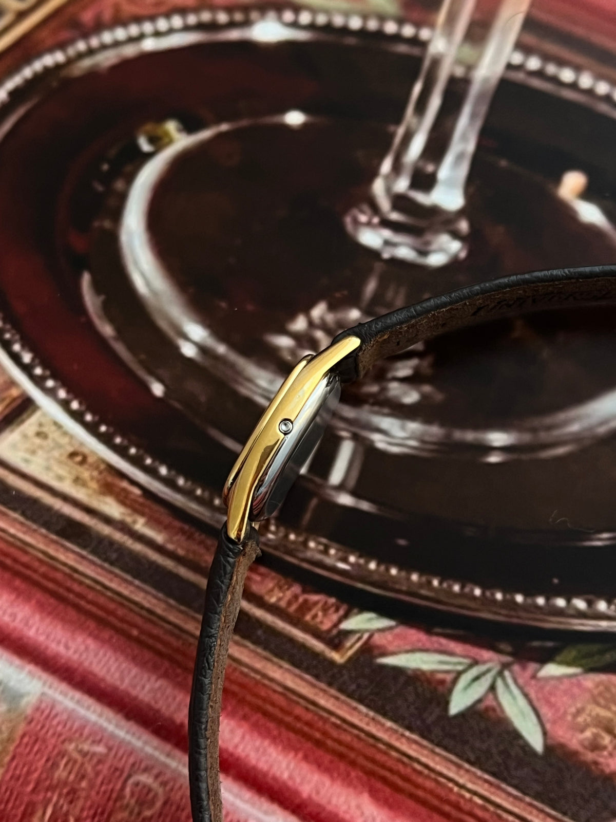 Side profile of the Omega De Ville gold-tone cushion case and integrated crown.
