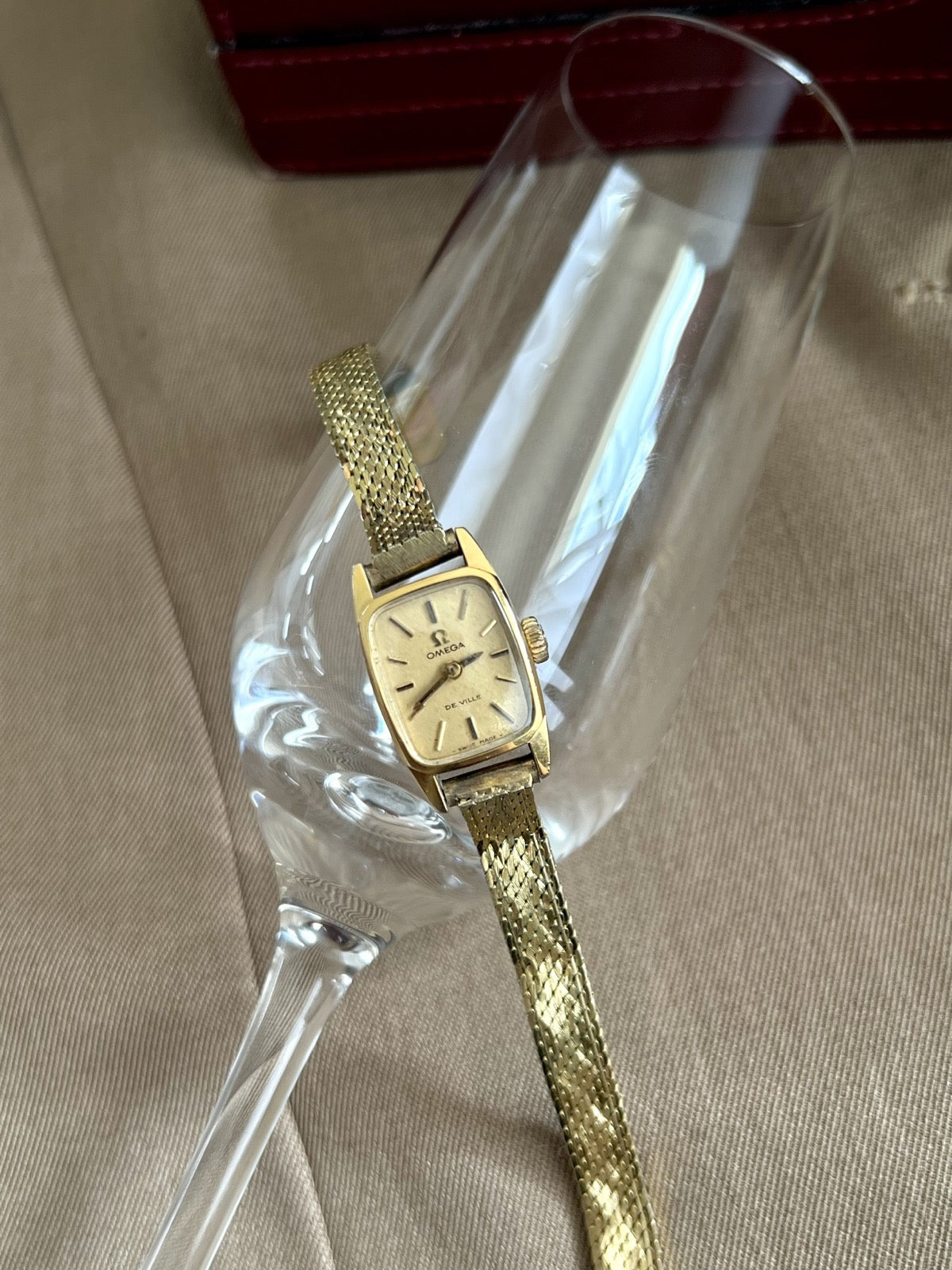 Front view of the Omega De Ville women’s watch with a gold snowflake dial and slender rolled gold bracelet
