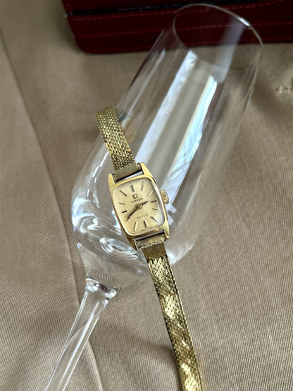 Front view of the Omega De Ville women’s watch with a gold snowflake dial and slender rolled gold bracelet