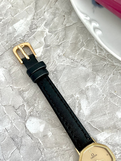 Dark stitched strap and gold-tone pin buckle on Omega De Ville rectangular women's watch