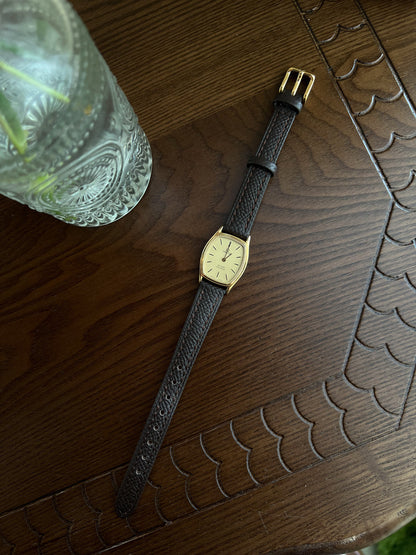 Omega De Ville tonneau grid dial women’s watch, angled view.