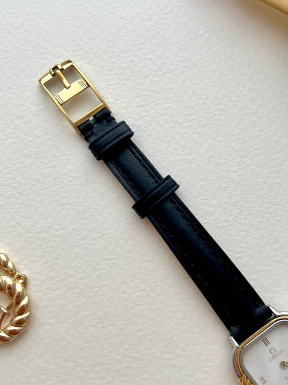 Full front view of the Omega De Ville white-dial watch with twisted gold column bezel.
