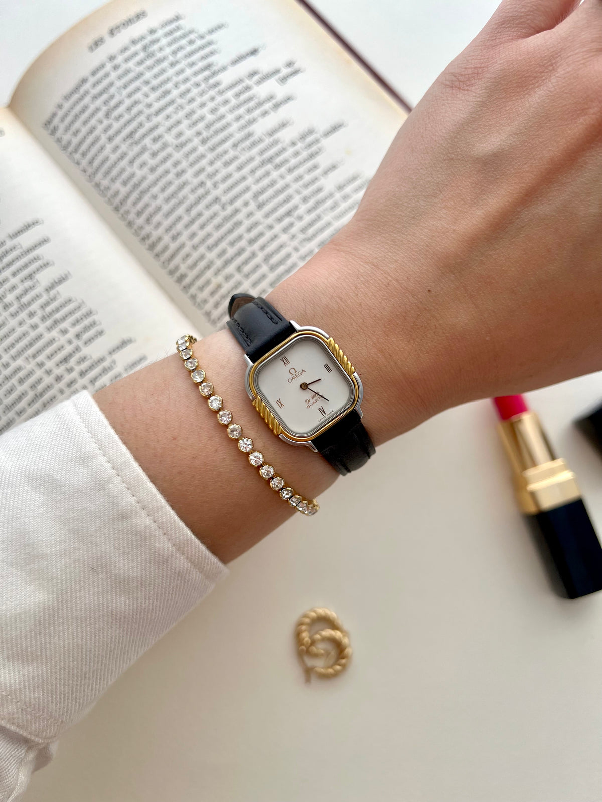 Close-up of the Omega De Ville white dial, gilt Roman numerals and twisted gold column bezel.