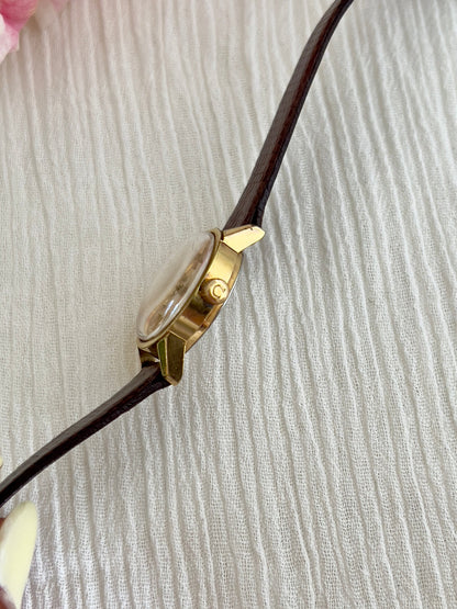 Close-up of the champagne sunburst dial on the Omega Geneve automatic watch.