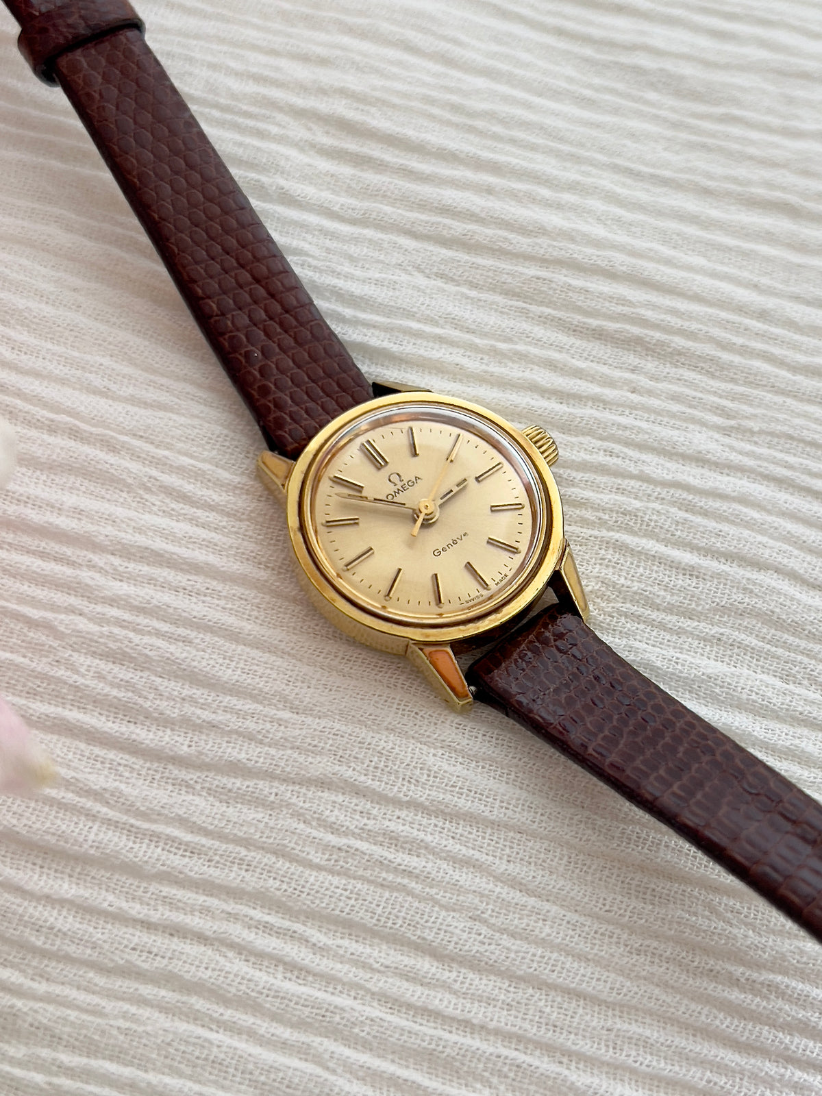 Omega Geneve automatic watch shown on a wrist.