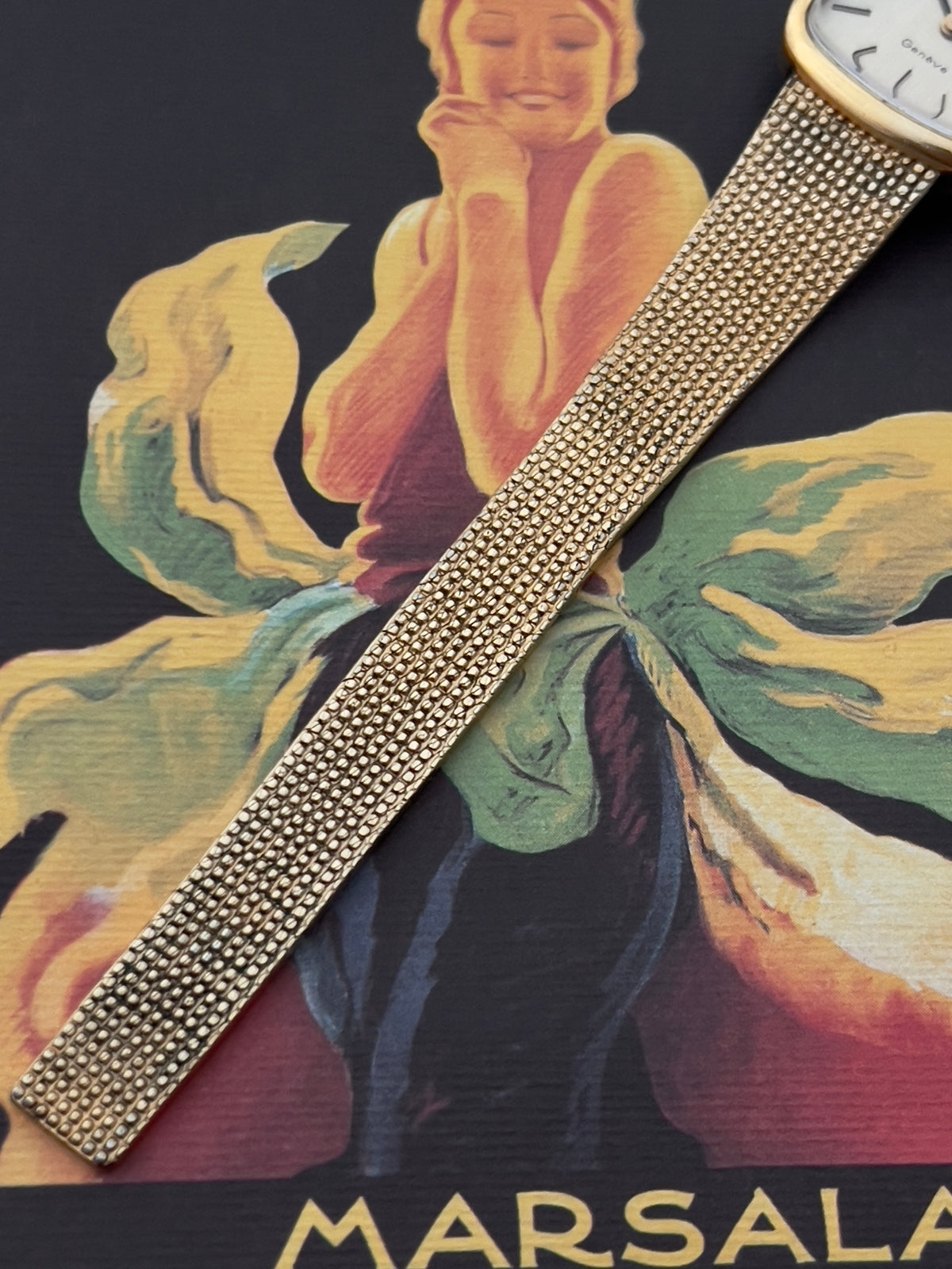 Side profile of the Omega Geneve case and gold-tone crown.