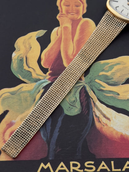 Side profile of the Omega Geneve case and gold-tone crown.