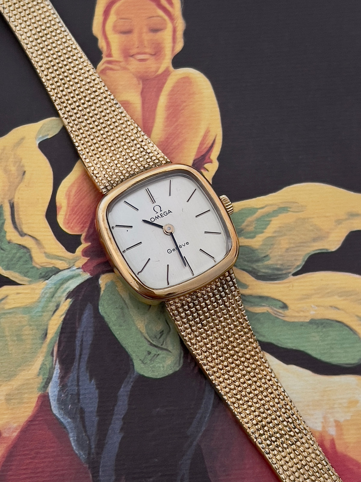 Close-up of the Omega Geneve dial with baton markers and Omega emblem.