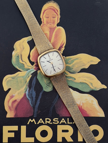 Angled view of the Omega Geneve gold-tone case and integrated mesh bracelet.