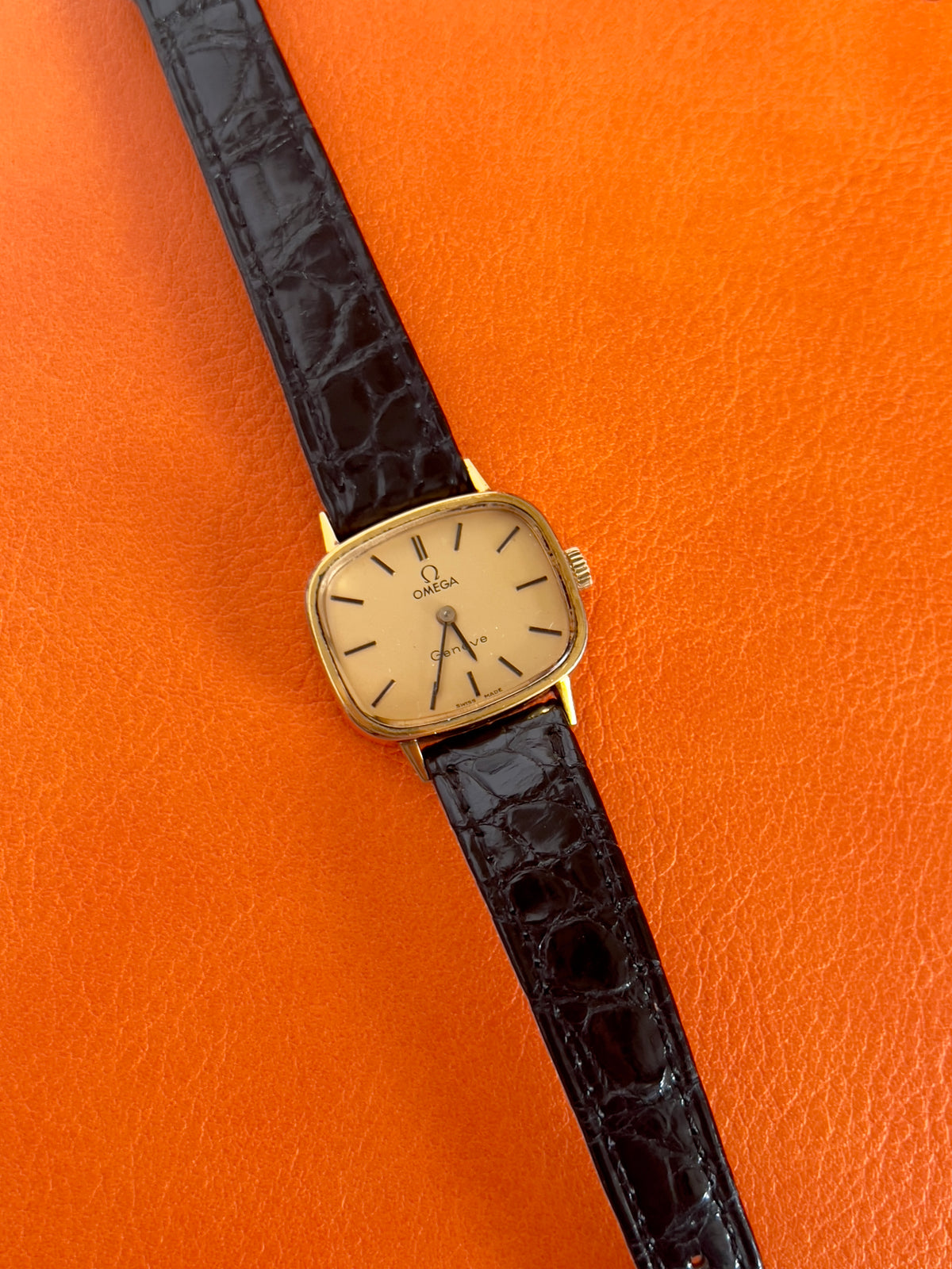 Watch with box of a vintage Omega gold-tone cushion watch with champagne dial.
