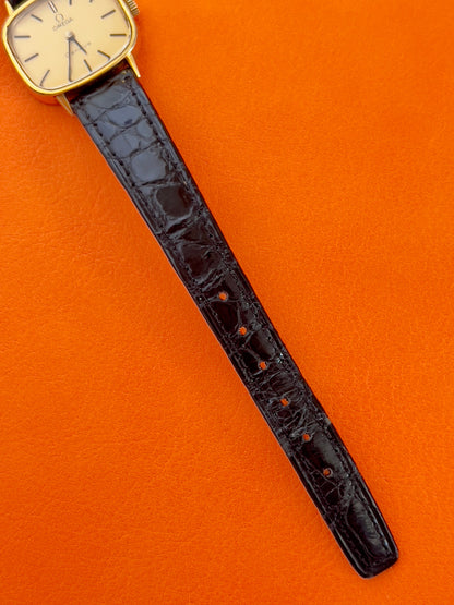 Case profile of a vintage Omega gold-tone cushion watch with champagne dial.