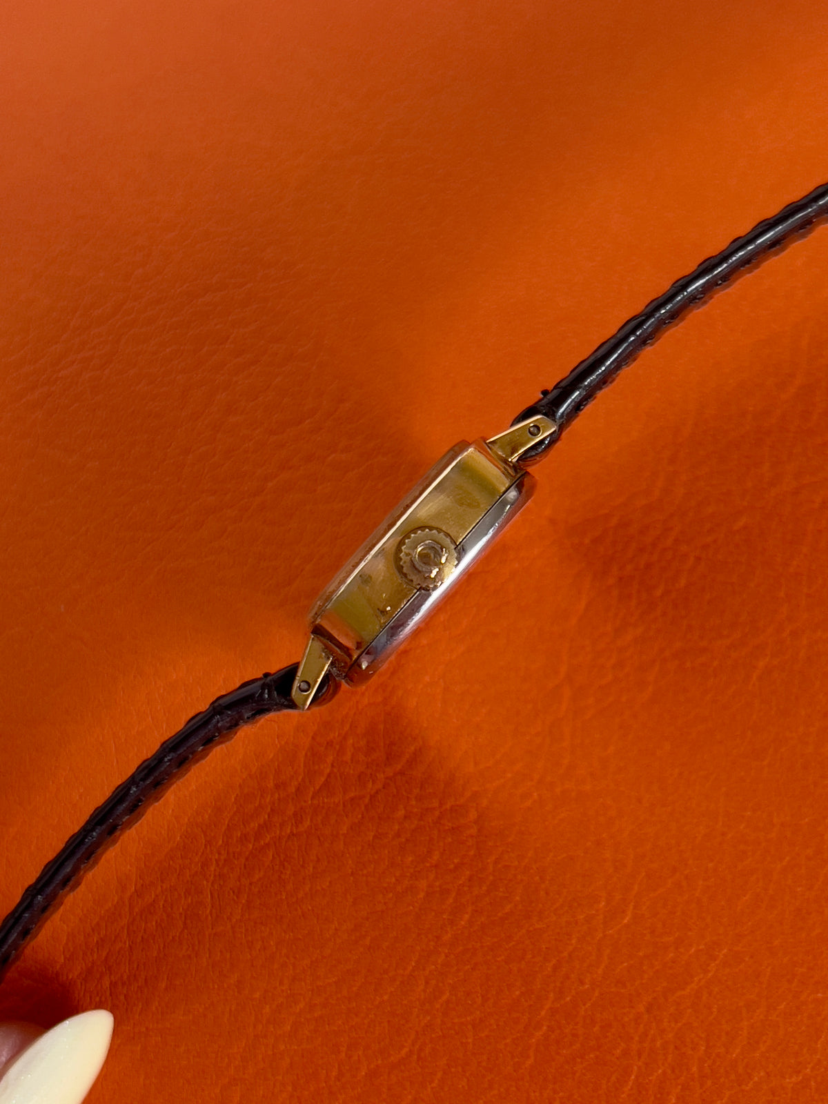 Close-up of the champagne dial of a vintage Omega gold-tone cushion watch with champagne dial.