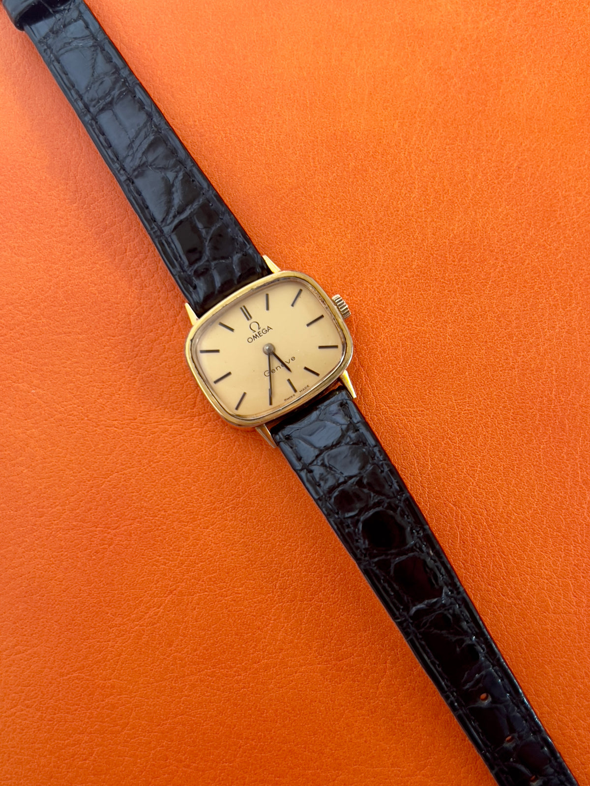 Champagne dial detail of a vintage Omega gold-tone cushion watch with champagne dial.