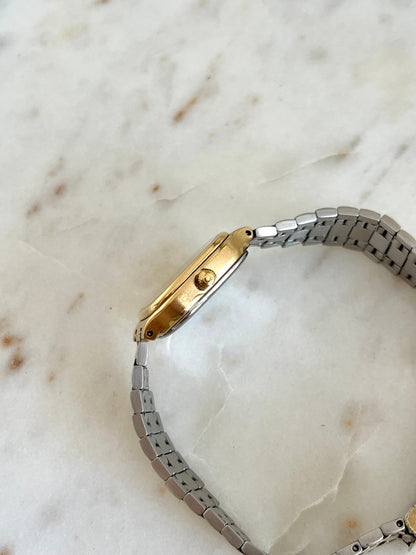 Side profile of the Omega Seamaster 596.0051, showing its Omega-signed crown, slim gold-tone case and steel back.
