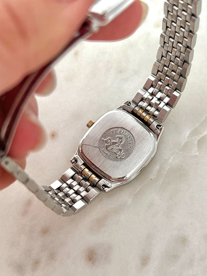 Caseback of Omega Seamaster Brest 396.1011 women’s watch showing Seamaster Quartz medallion and original two tone bracelet end links