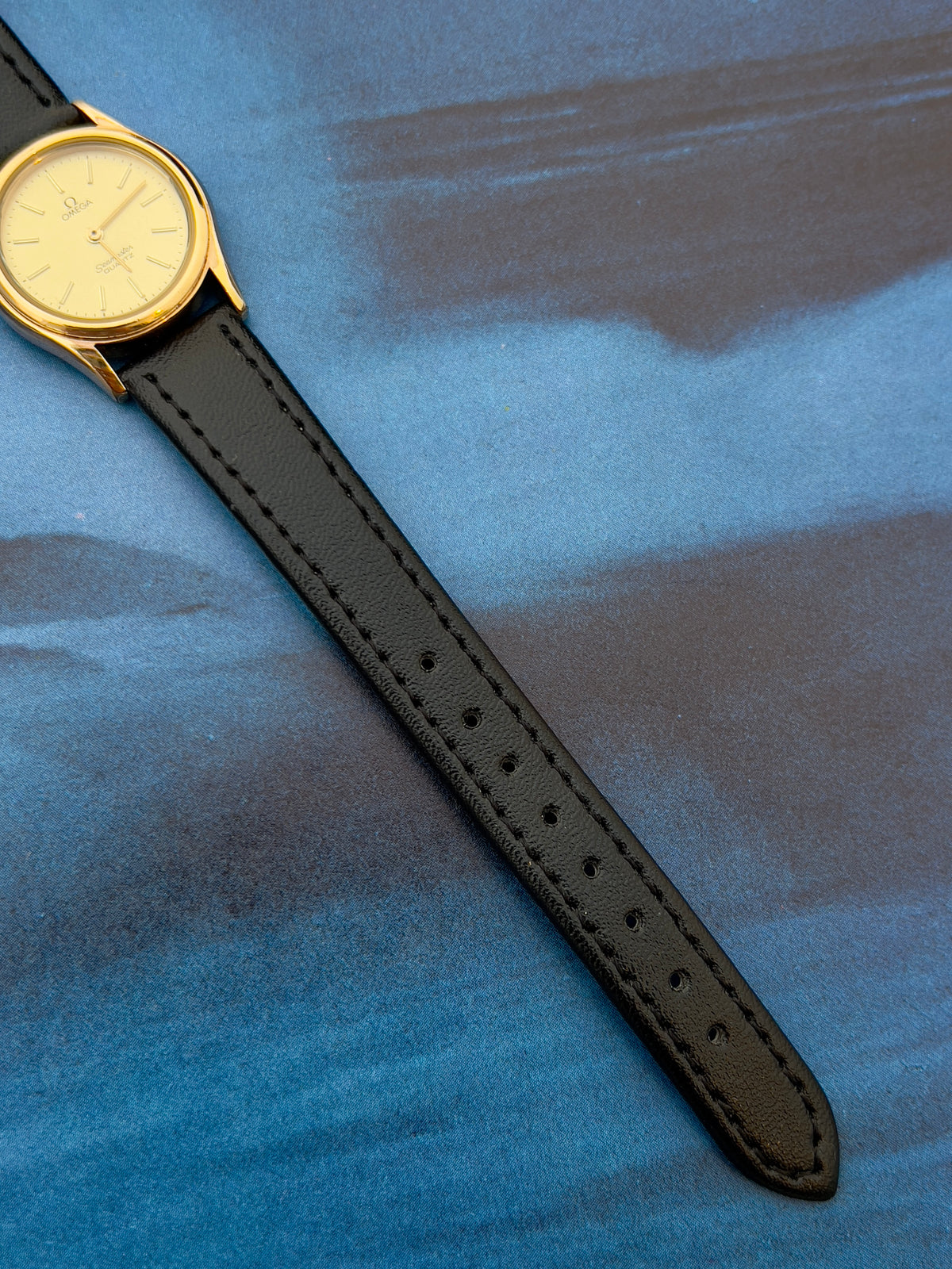 Angled view of the Omega Seamaster gold watch with champagne dial.