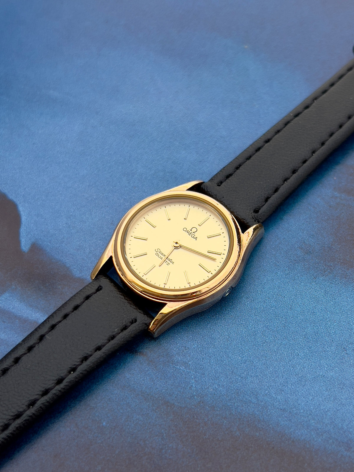 Omega Seamaster gold-tone watch shown with its box.