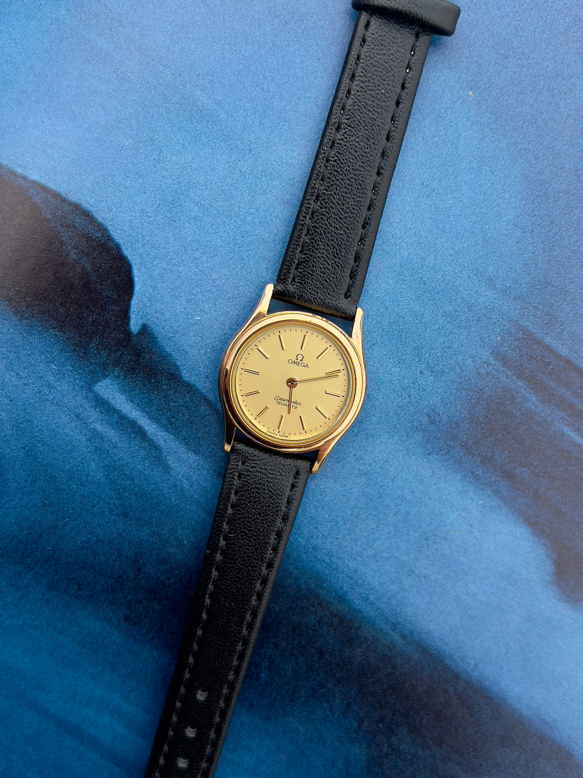 Side profile of the gold-tone case on the Omega Seamaster.